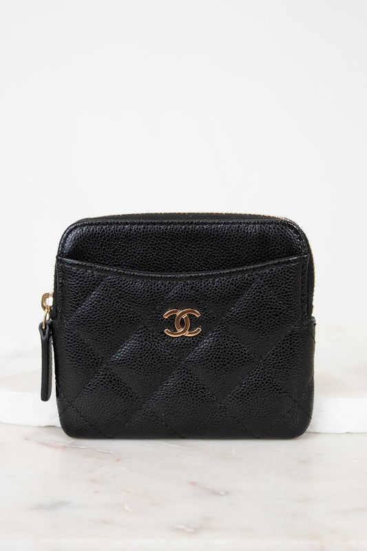 Black quilted wallet with gold logo on a white background