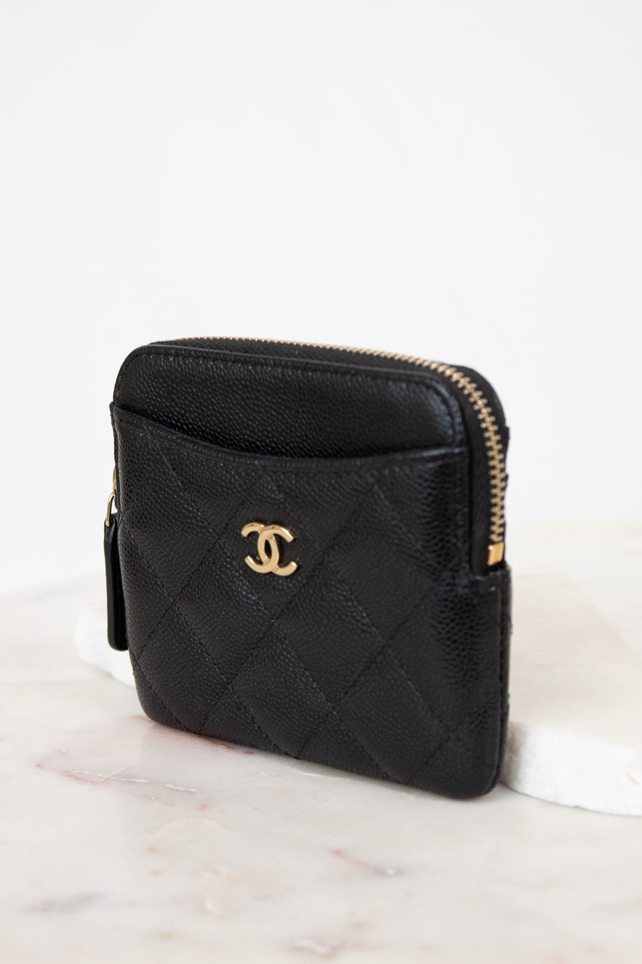 Black quilted wallet with gold logo on a white background