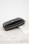 Black quilted wallet with gold logo on a white background