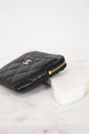 Black quilted wallet with gold logo on a white background