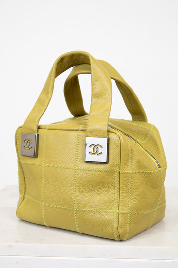 Green handbag with Chanel logo on a white background