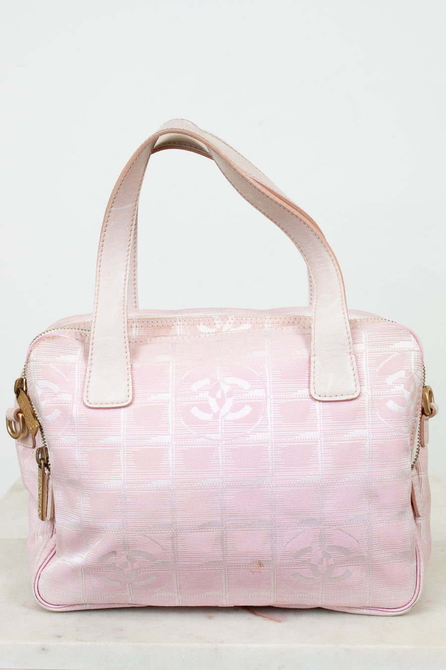 Pink handbag with a logo on a light background