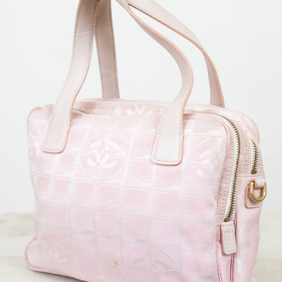 Pink handbag with a gold zipper on a white background