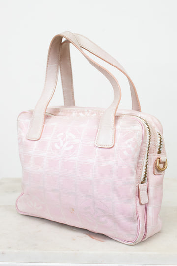 Pink handbag with a gold zipper on a white background