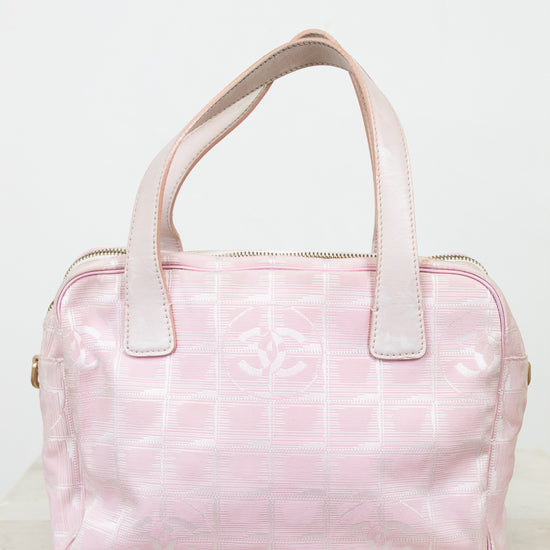 Pink handbag with white handles on a light gray background