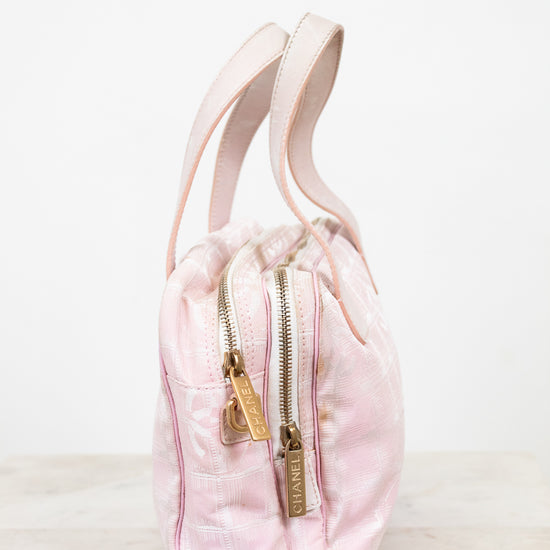 Pink drawstring bag with gold zipper on a white background