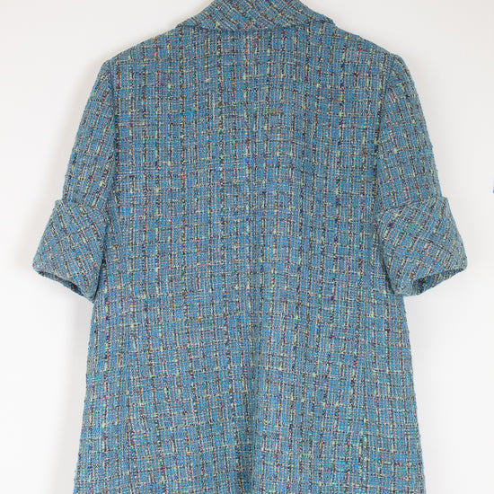 Blue patterned shirt on a hanger against a white background
