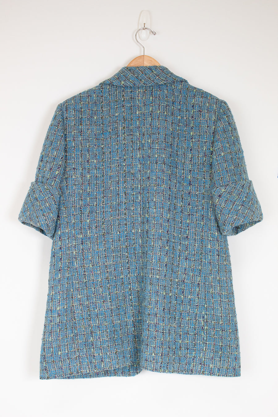 Blue patterned shirt on a hanger against a white background