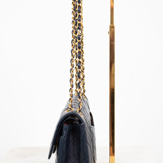 Navy handbag with gold chain on a white background