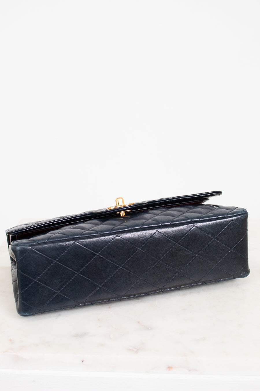 Navy quilted handbag on a white background