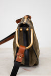 Handbag with gold hardware and leather strap on a white background