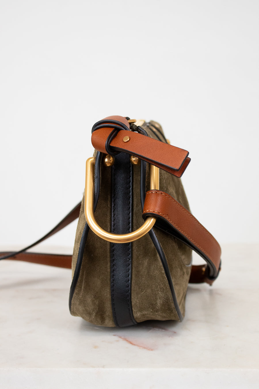 Olive suede handbag with gold hardware on a white background