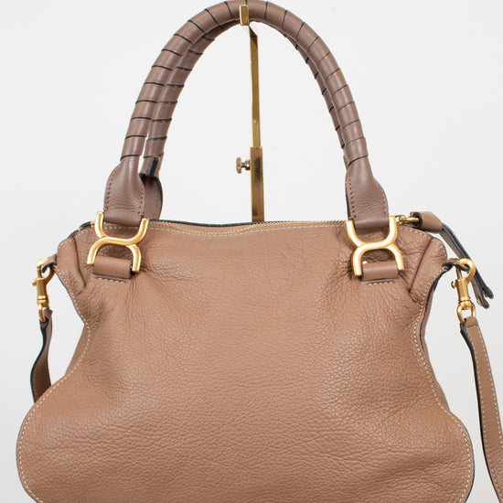 A taupe brown pebbled leather handbag with a braided top handle, gold-tone hardware, and a matching shoulder strap, displayed on a stand against a white background.