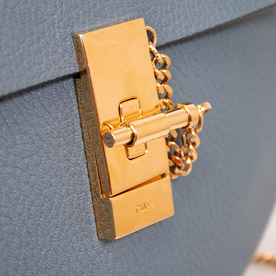 Gold lock on a blue textured leather surface