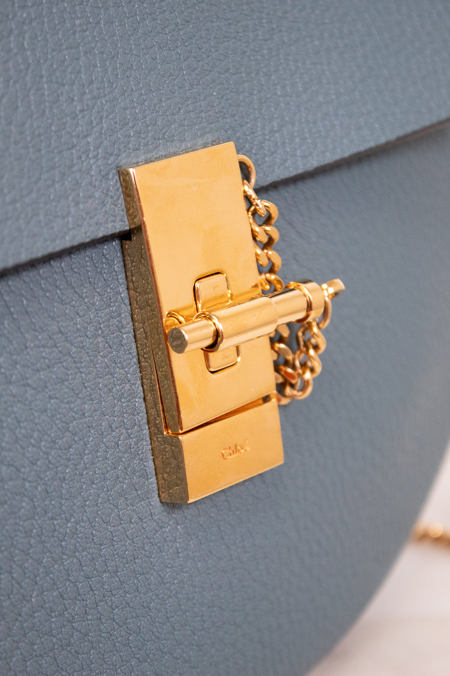Gold lock on a blue textured leather surface