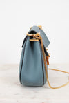 Blue handbag with a gold chain on a white background