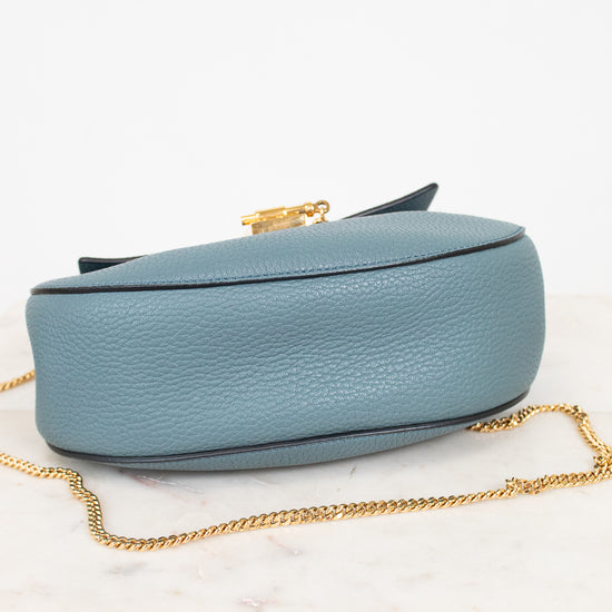 Blue handbag with a gold chain on a white background