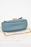 Blue handbag with a gold chain on a white background