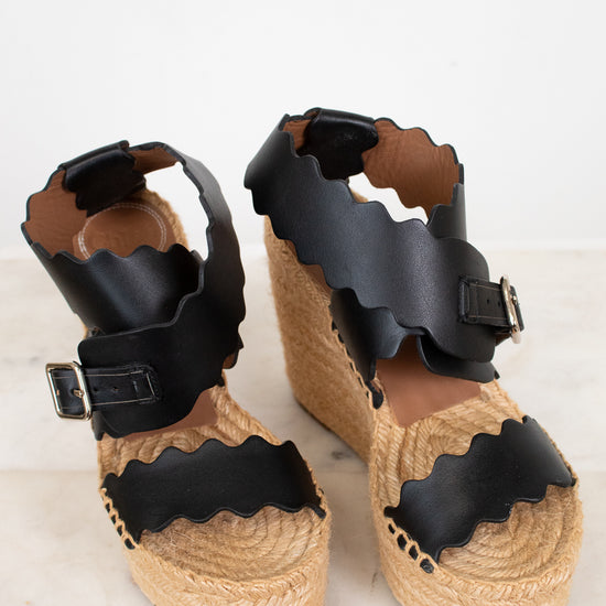 Pair of sandals with black straps on a light background