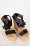 Pair of sandals with black straps on a light background