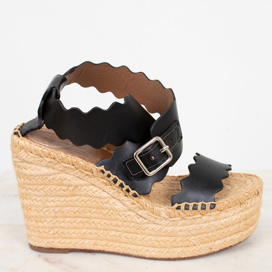 Black wedge sandal with espadrille sole on a white background