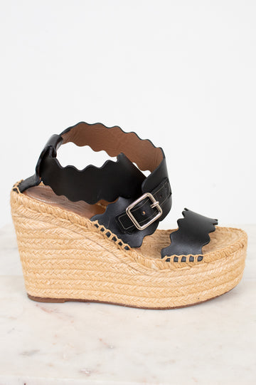 Black wedge sandal with espadrille sole on a white background