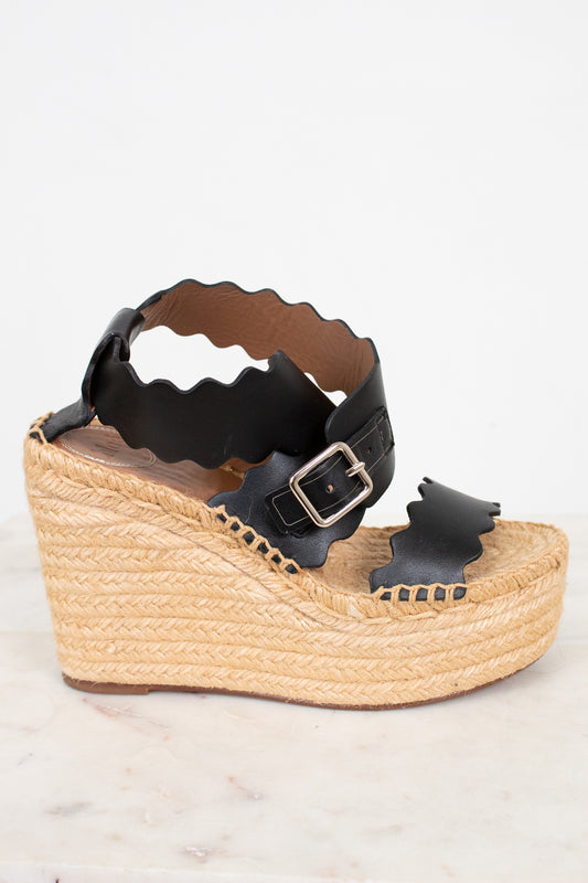 Black wedge sandal with espadrille sole on a white background