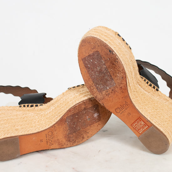 Close-up of wooden sandals with visible brand logo on a light background