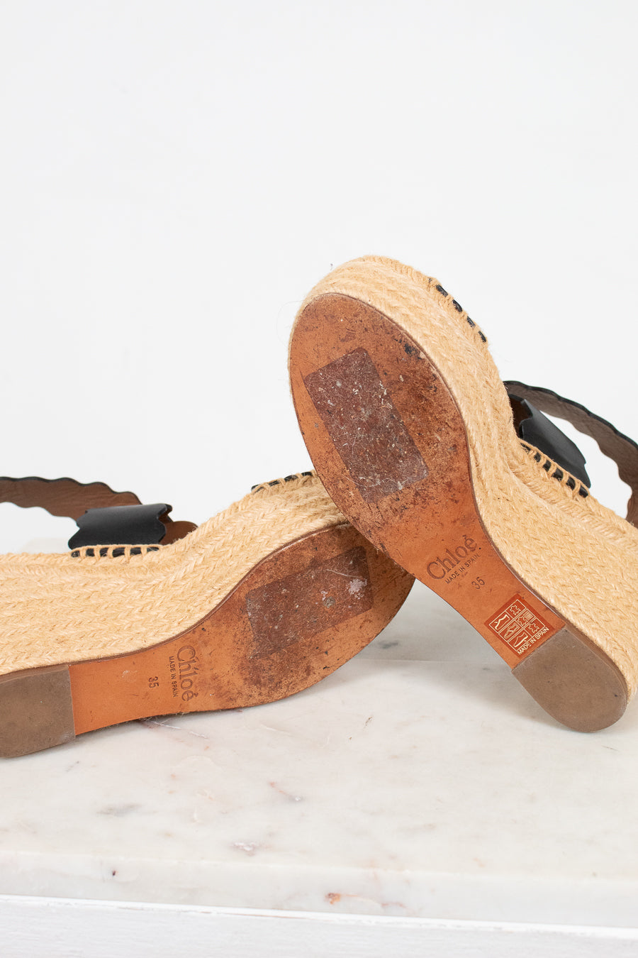 Close-up of wooden sandals with visible brand logo on a light background