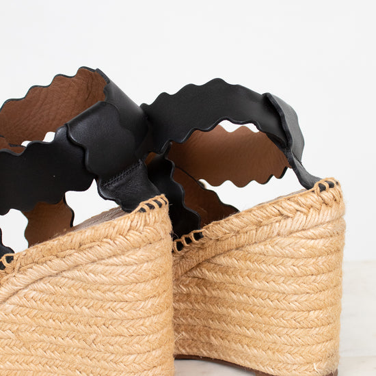 Woven sandals with black straps on a light background