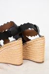 Woven sandals with black straps on a light background
