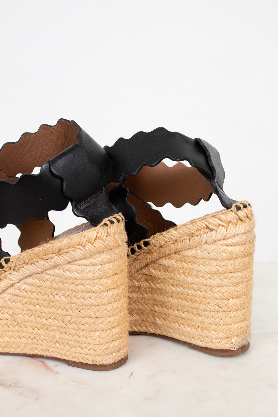 Woven sandals with black straps on a light background