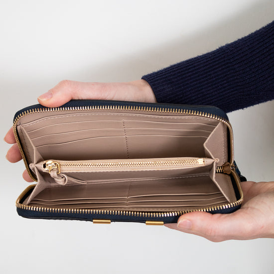 Person holding an open wallet with a plain background