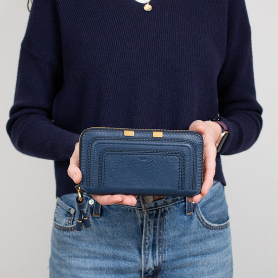 Person holding a blue wallet against a plain background