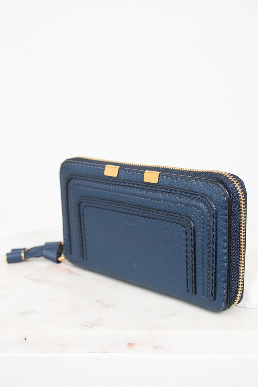 Blue wallet with gold zipper on a white background