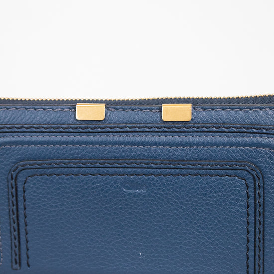 Blue wallet with gold zipper on a light gray background