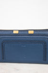 Blue wallet with gold zipper on a light gray background