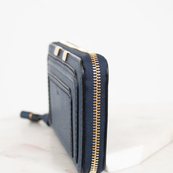 Navy blue wallet with gold zipper on a white background