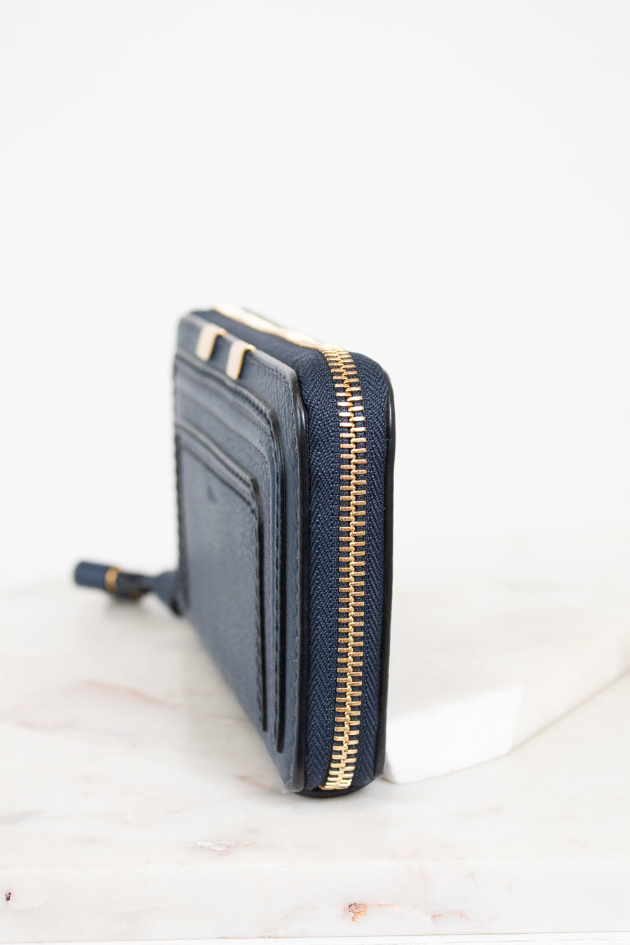 Navy blue wallet with gold zipper on a white background