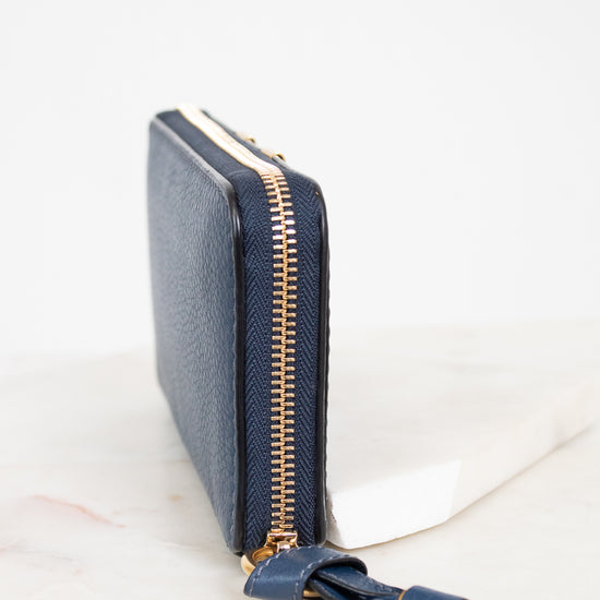Navy blue wallet with gold zipper on a white background
