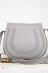 Grey leather saddle crossbody bag on white background