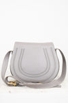 Grey leather saddle crossbody bag on white background