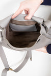 Inside view of grey leather saddle crossbody bag on white background
