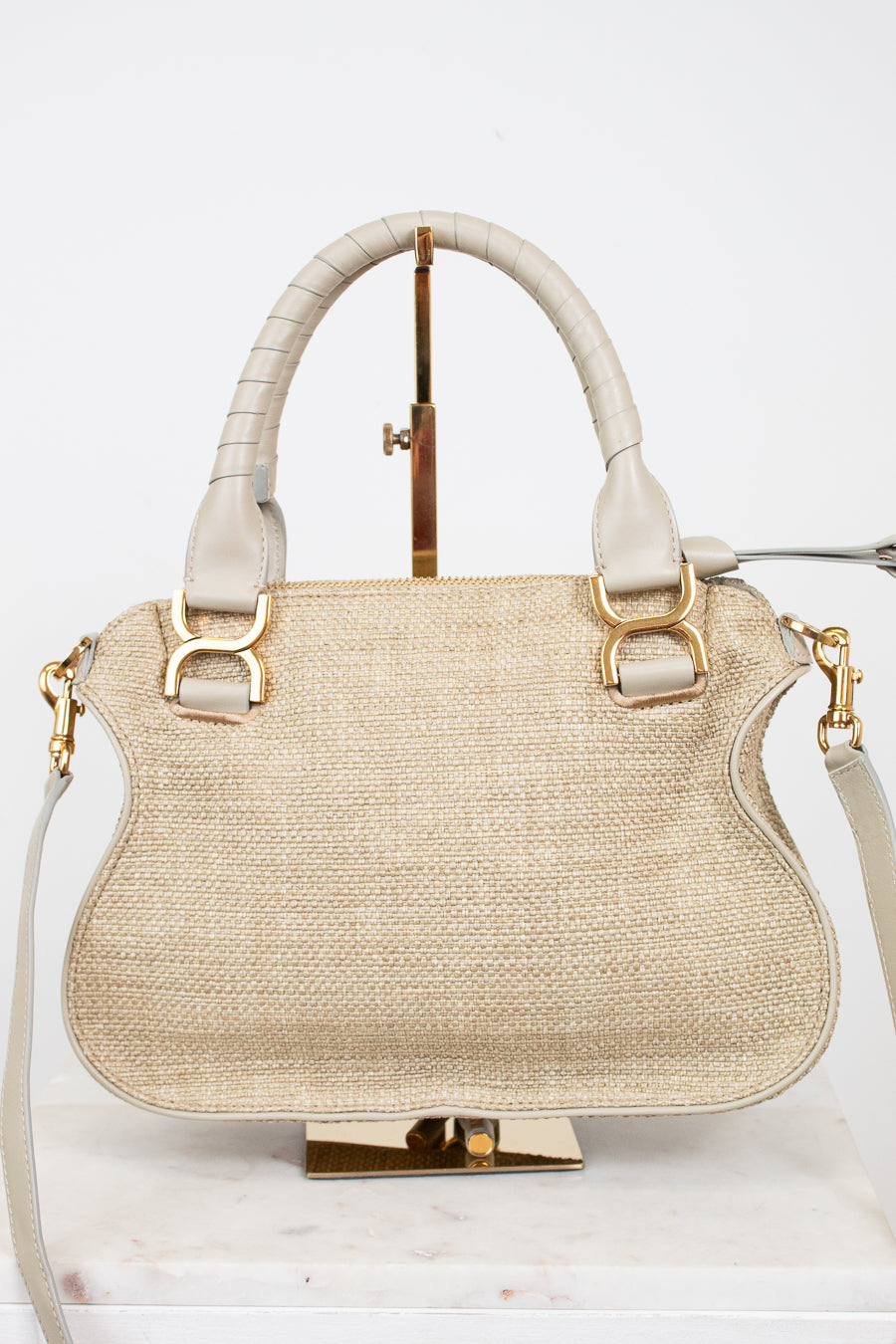 Beige handbag with gold accents on a white background