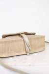 Beige woven handbag with a strap on a white background