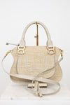 Beige handbag with straw texture and gold accents on a white background