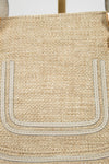 Close-up of a woven handbag with visible branding
