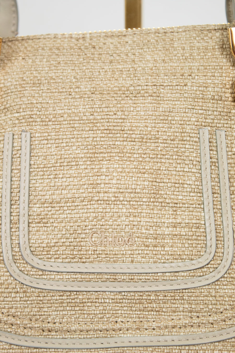 Close-up of a woven handbag with visible branding