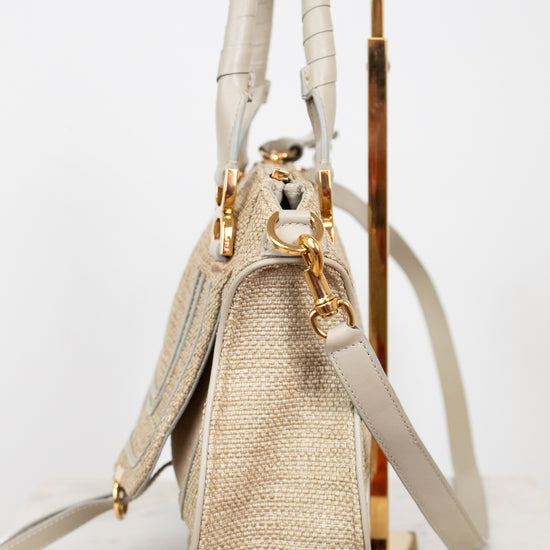 Beige handbag with gold accents on a white background