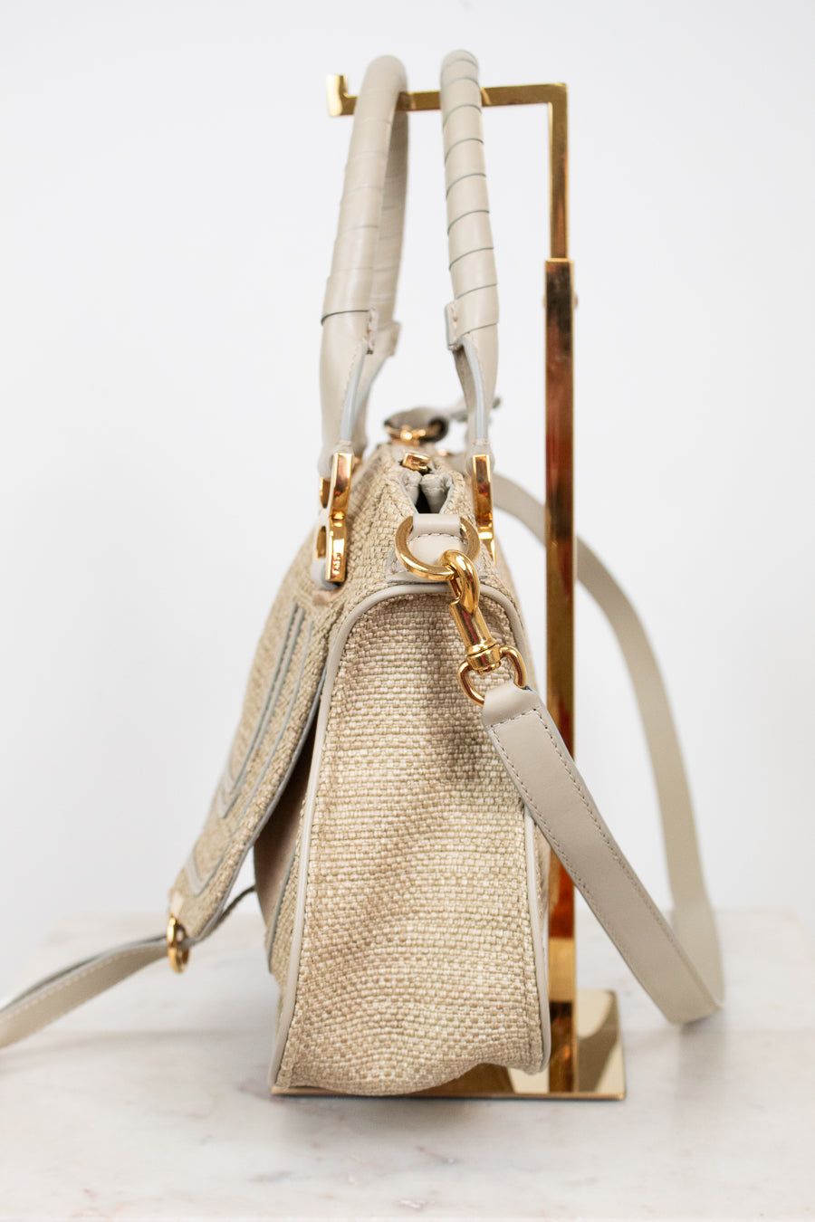 Beige handbag with gold accents on a white background